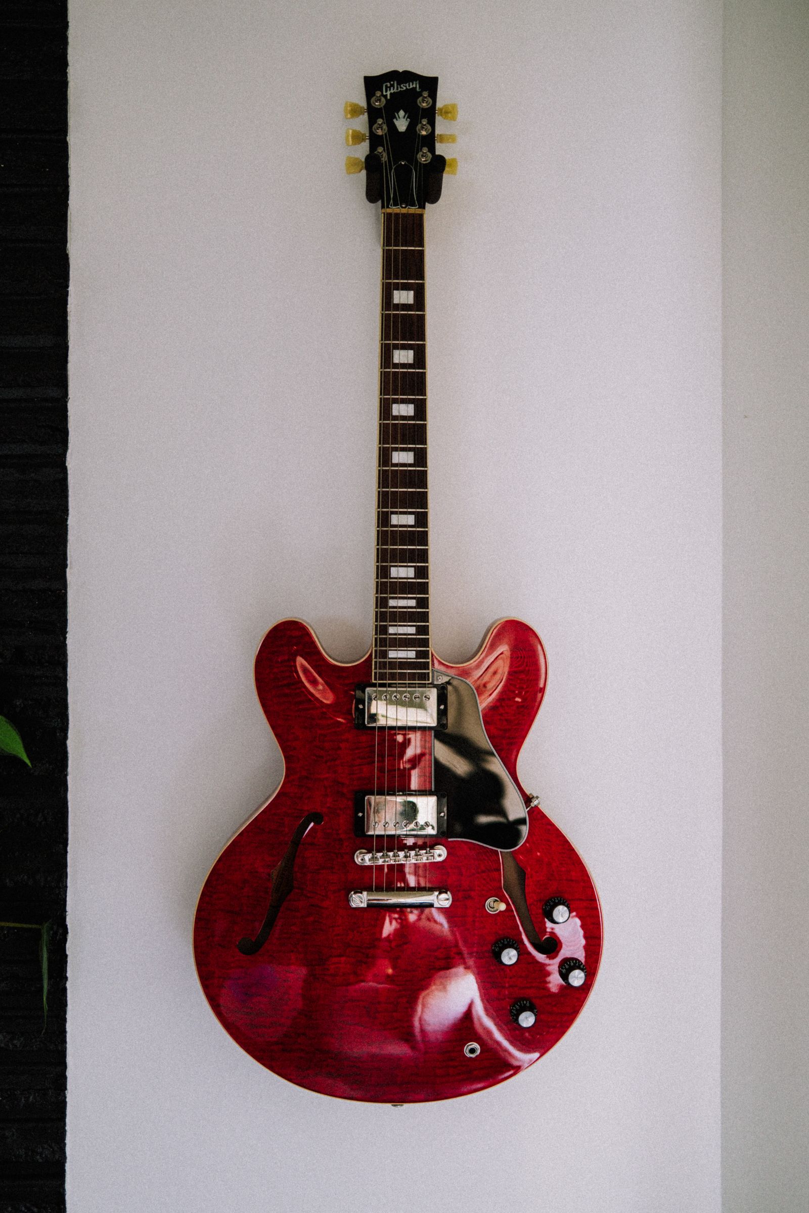 guitarra semi-hollow pendurada em suporte de parede
