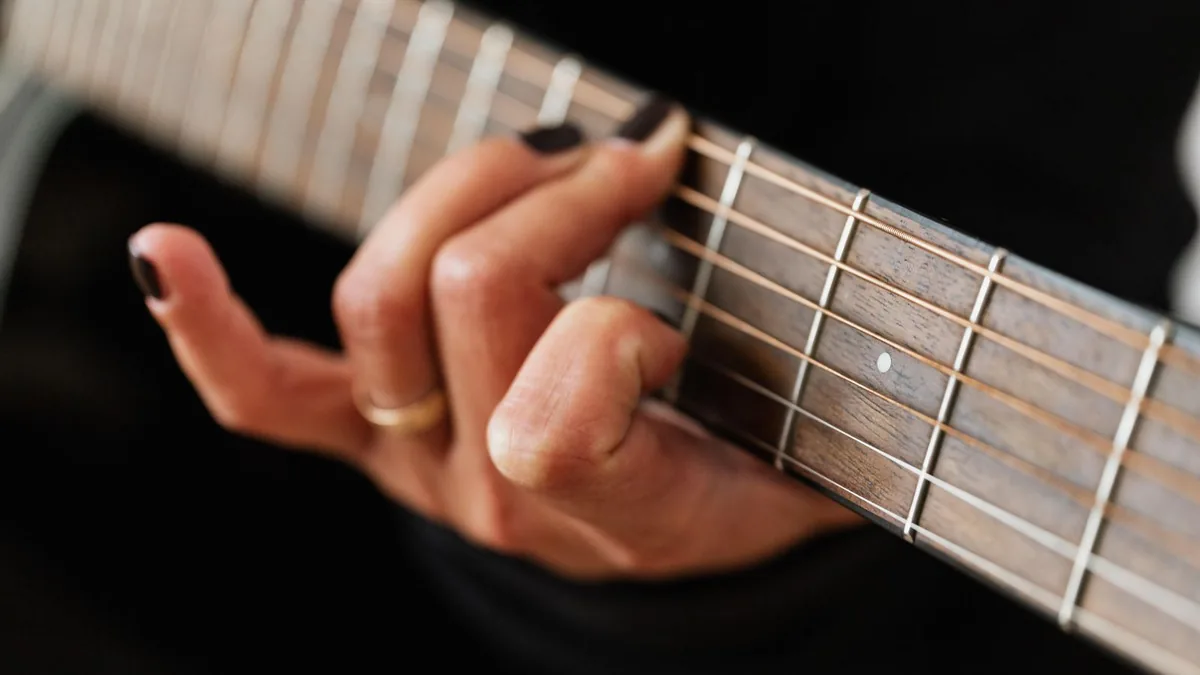 guitarrista praticando a troca de acordes, m&atilde;o em posi&ccedil;&atilde;o no bra&ccedil;o da guitarra