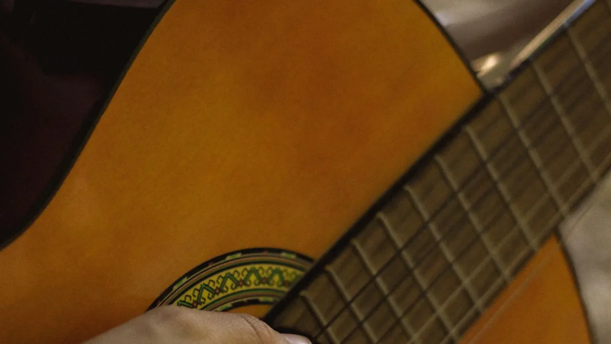 mão posicionada no braço do violão durante a checagem da afinação