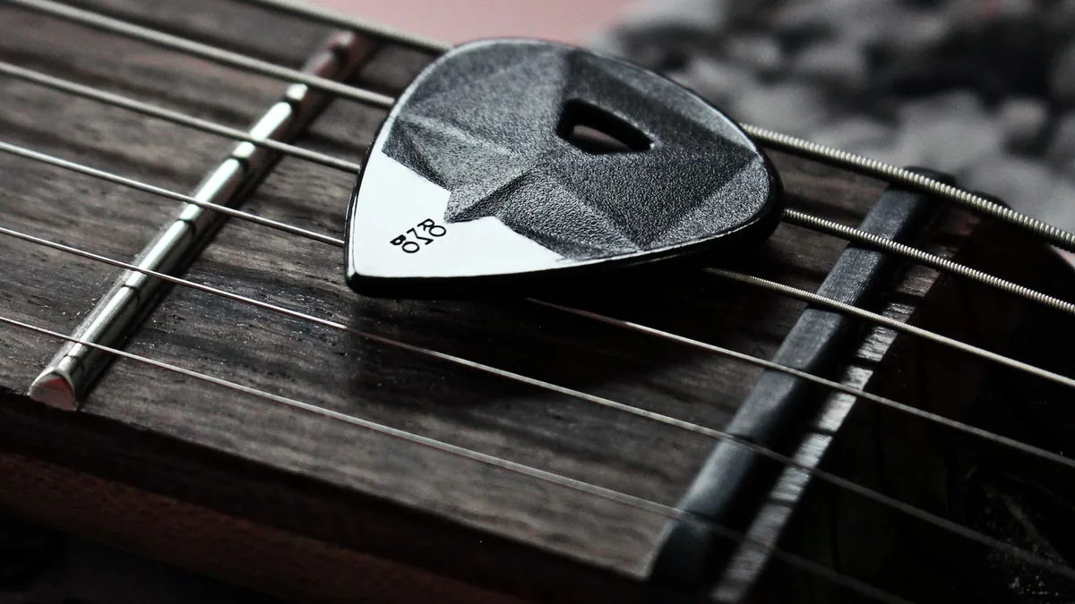 Palheta apoiada sobre as cordas da guitarra — curso Speed Picking de palhetada alternada