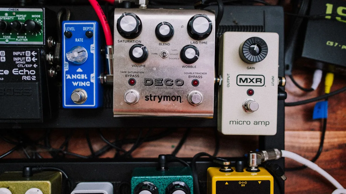 pedalboard montado com vários pedais ligados em sequência por cabos patch